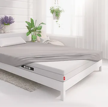 Het BODYGUARD®-matras, voor de helft bedekt met het zilverkleurige Jersey-hoeslaken.