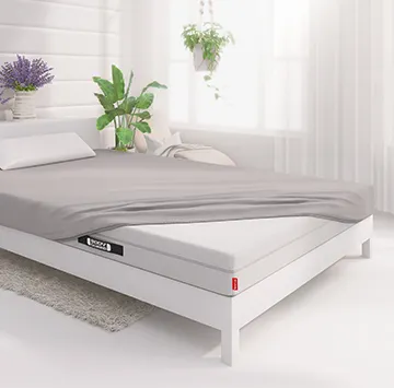 Een BODYGUARD® matras, voor de helft voorzien van een zilverkleurig BODYGUARD® jersey hoeslaken.