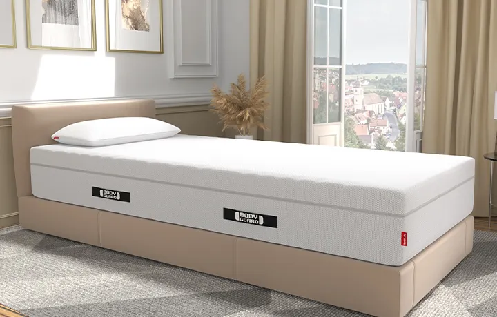 BODYGUARD® boxspringmatras op een beige gestoffeerd bed
