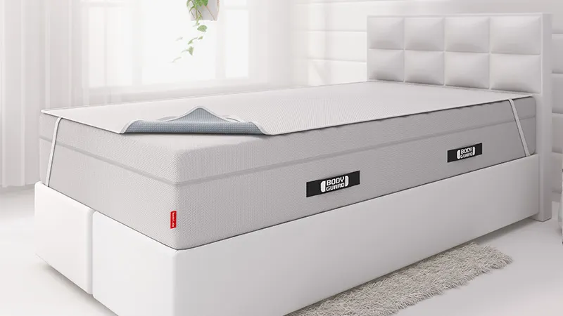 Op een boxspringbed liggen het BODYGUARD® Boxspring-matras met daarop de BODYGUARD® incontinentie-onderlegger.