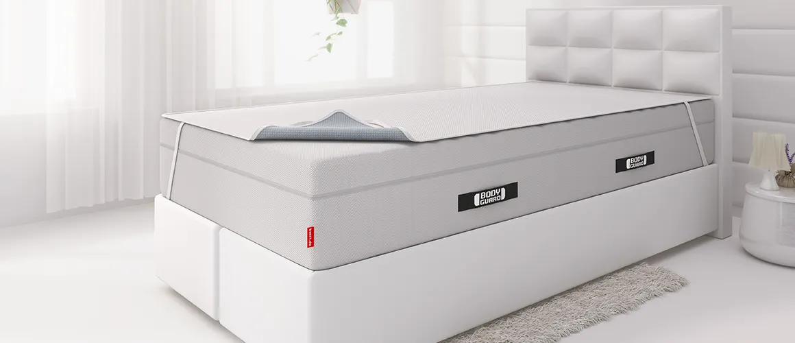 Een boxspringbed met een hoge matras waarop een incontinentiehoes is gespannen.