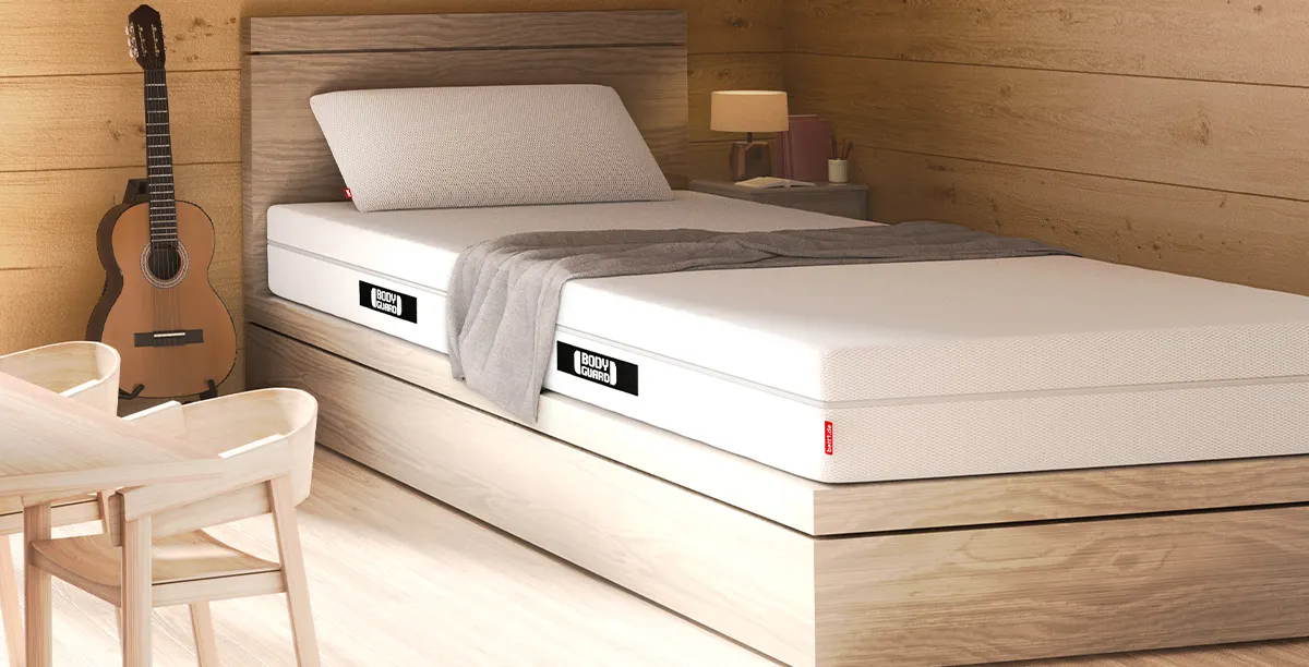 Foto: een matras in een sober ingerichte houten ruimte.