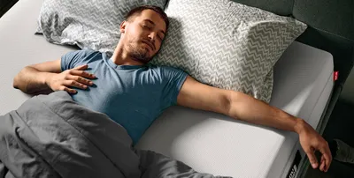 Foto: een persoon ligt op de rug op een QXSchaum®-matras.