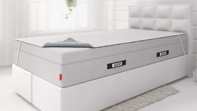 Op een boxspringbed liggen het BODYGUARD® Boxspring-matras met daarop de BODYGUARD® incontinentie-onderlegger.